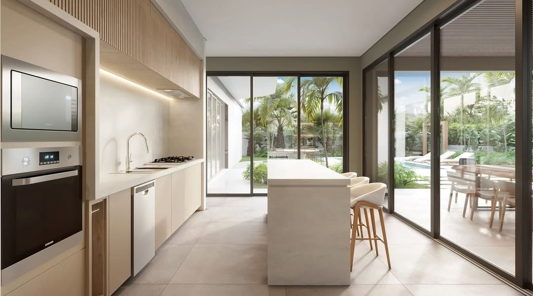 Estudo tridimensional da Casa LM: cozinha em corredor com ilha, marcenaria clara e vista para area de piscina.